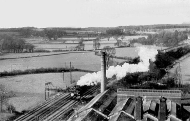 Further sorting through my late father's photographs produced the one attached. It was almost certainly taken from the top of the newer of the two brickworks chimneys (demolished in the 1970's I believe) and shows a general view over the roofs of the brickworks buildings with the older, shorter chimney centre foreground. A Bristol-bound goods train is seen about to pass beneath the gantry which carried the aerial ropeway from the claypits to the brickworks. My guess is that the photo was taken late 1950's or early 1960's maybe during the chimney's construction. :  : 
